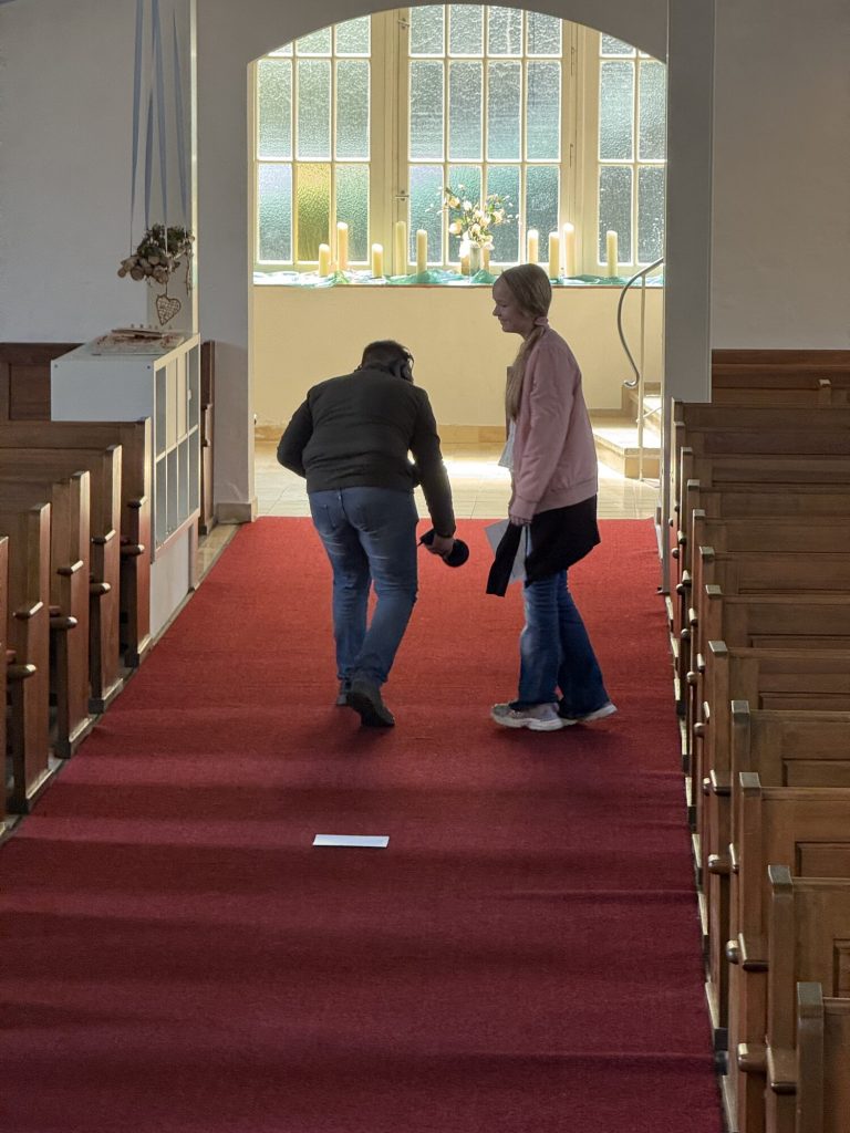 Zwei Mitglieder der Gruppe nehmen im Mittelgang der Apostelkirche Geräusche auf.